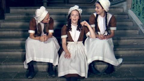 Three girls sat on steps.