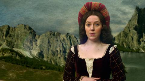 Gemma Whelan dressed as Mona Lisa against a painted landscape.