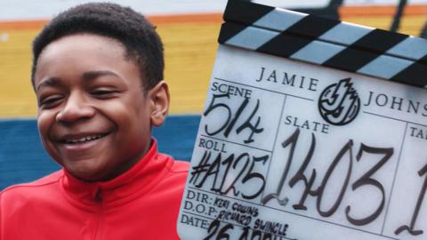 Freddie from Jamie Johnson laughing next to a clapper-board.