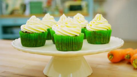 5 carrot cupcakes on a stand.