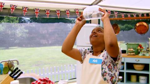 A girl holds a bowl of whipped meringue upside down over her head to see if it is done.