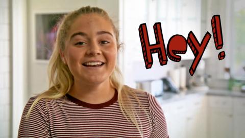 Tilly Ramsay smiles with the word 'Hey!' next to her in red letters.