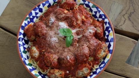 A bowl of spaghetti and meatballs.