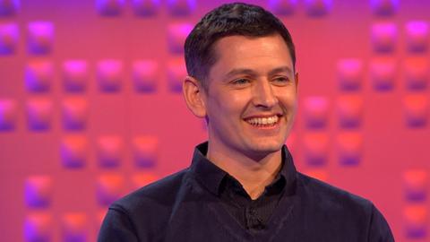 Man with black shirt smiling.