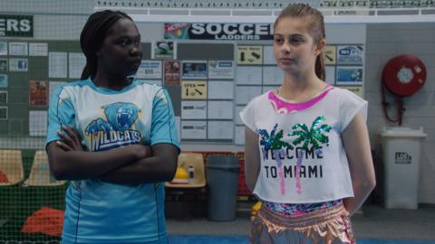 Marnie and Ruby are standing in a sports hall.