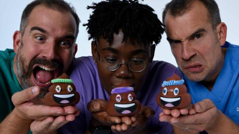 Three doctors in scrubs holding up small models of cartoon poo, Dr Xand, Dr Ronx and Dr Chris from Operation Ouch.