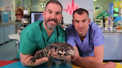 Dr Chris and Dr Xand with a lizard in the Op Ouch lab.