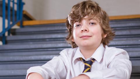 Two boys posing in a school corridor.