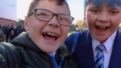 A boy (school student) laughing.