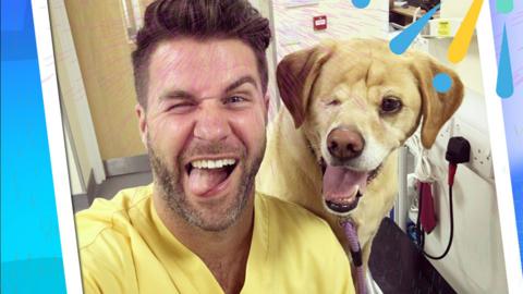 A man (vet) pulling a face with a one eyed dog.