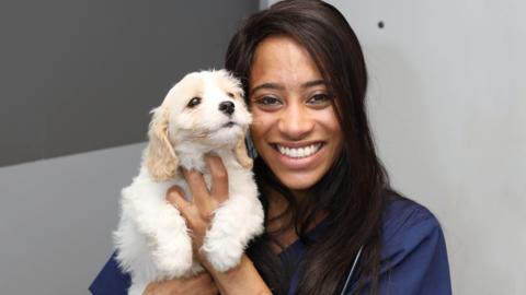 Vet Cheryl holding a puppy.