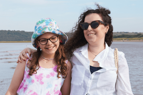 Tracy and Jess looking happy by the sea.