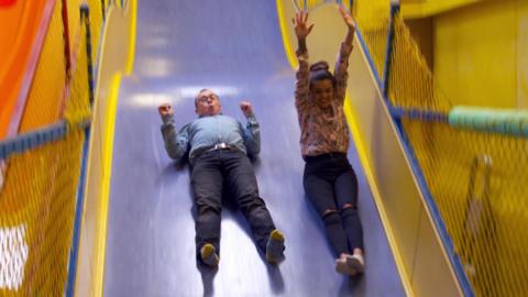 Lauren and Joe sliding down a slide.