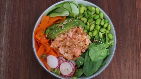 A bowl of vegetables and salmon.