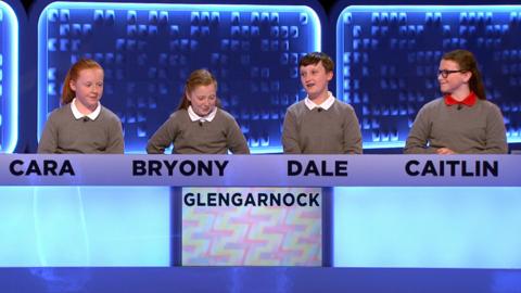 Four students sit together in a studio.