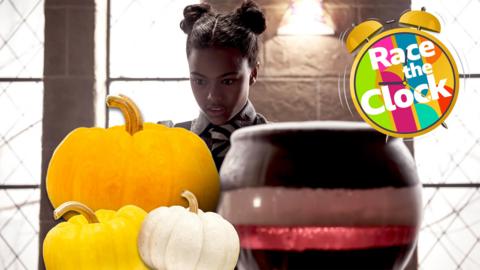 A young girl mixing potions in a cauldron with a pile of pumpkins in front of her.