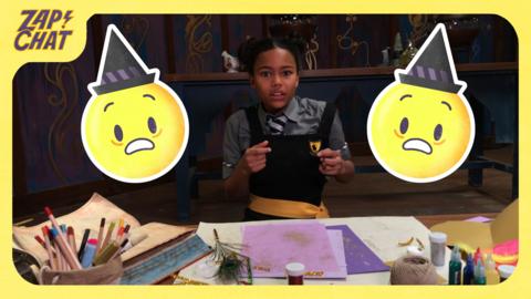 A girl sitting at a desk and looking worried with two worried emojis next to her. Enid from The Worst Witch.