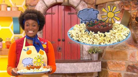 Big Cook is standing holding a plate. A close up of the plate shows popcorn and salsa.