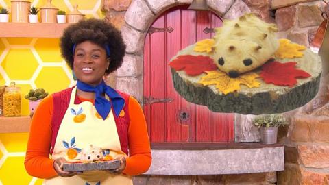 Big Cook is smiling and holding the finished hedgehog rolls, whilst a larger version of the rolls are visible at the top right.