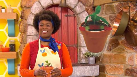 Big Cook is holding a plant pot with a gummy worm on top.