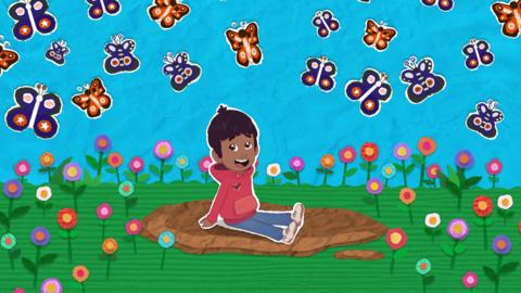 Nikhil, a young south Indian boy, sitting on the lawn, looking at dozens of cartoon butterflies above him