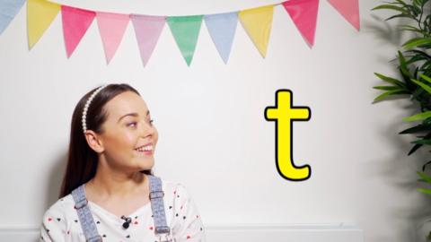 Evie looks at the letter T as she learns how to pronounce it.