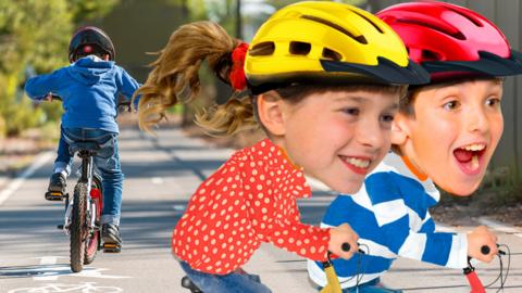 Image of Topsy and Tim on bikes smiling. In the background you can see a boy riding down a cycle path