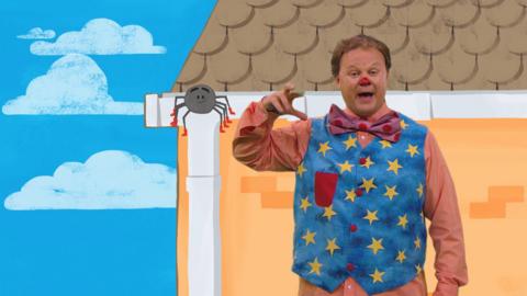 Mr Tumble and a spider on top of a house