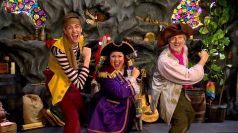 three pirates; captain captain, sandy and seaweed are smiling and have their arms swinging ahoy pirate style.