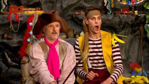 Two pirates, Sandy and Seaweed are sitting down, one looks really shocked.
