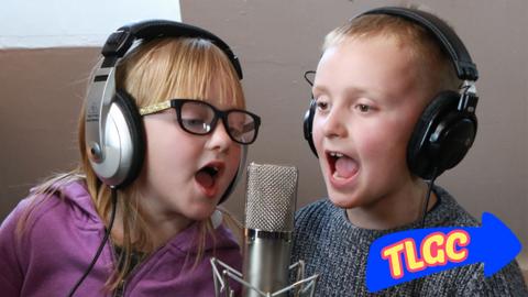 Two children singing into a microphone