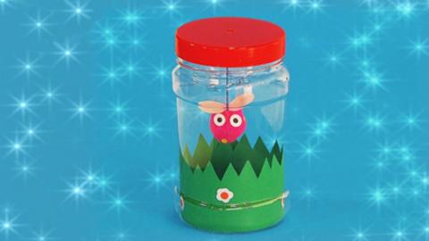 A colourful pom-pom bug in a jar.