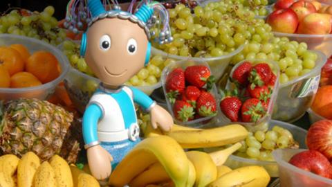 Mo Mo the Robot from Show Me Show Me sat amongst some fruit.