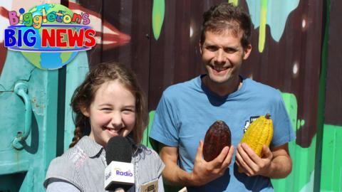 Beadie and her dad Pablo are outside, standing next to a brightly coloured building where the chocolate is made.