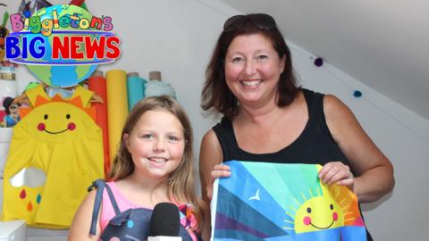 Lila and her mum Kirsty are in the studio with colourful fabric in the background.