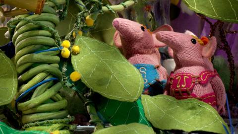 Tiny and Small Clanger from The Clangers staring at an enormous plant.