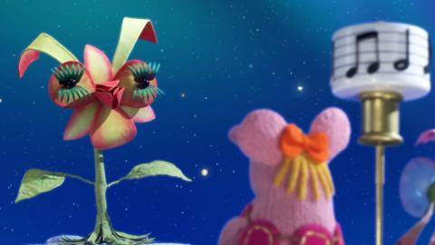 Tiny Clanger from The Clangers staring at a singing flower.