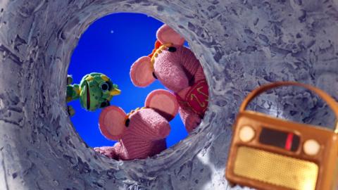 Tiny and Small Clanger and Baby Soup Dragon from The Clangers staring into a crater at a strange box.