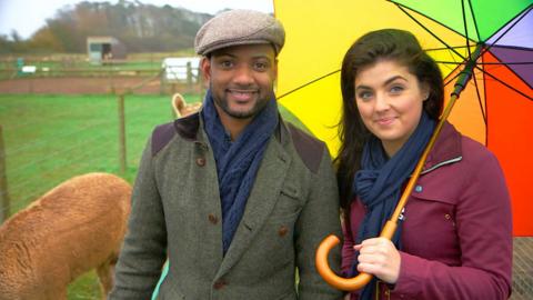 JB and Storm from Down On The Farm, outside in a field with an umbrella.