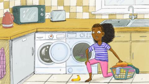 Enna Gee is kneeling down in the kitchen next to the washing machine, holding a washing basket full of clothes.