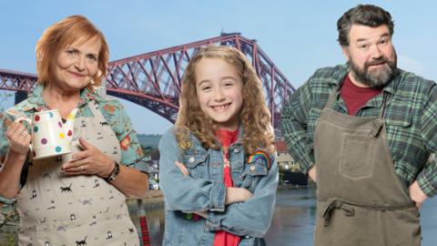 Mrs Juniper, Molly and Bob from Molly and Mack are standing in front of Bridgetown.