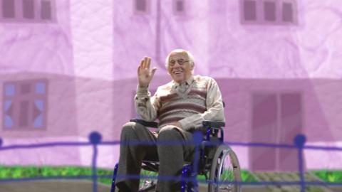 Grandpa Pops from Old Jack's Boat sitting in a wheelchair and waving from the shore.