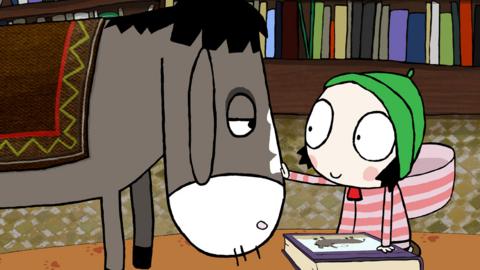 Sarah and Duck in a library, stroking a donkey.