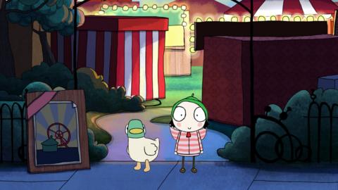 Sarah and Duck in front of a fairground.