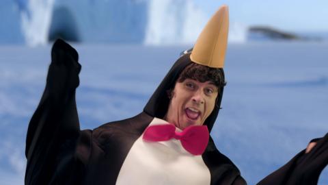 Andy dressed as a penguin wearing a red bow tie.