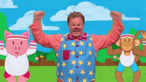 Mr Tumble exercises and plays outside.