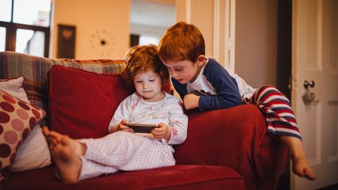 A young girl and boy looking at a smartphone