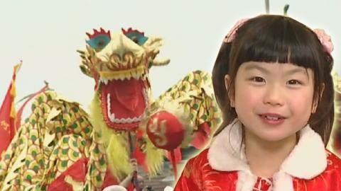 Young girl smiling standing in front of gold Chinese dragon