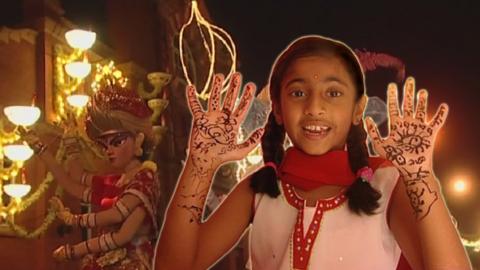 A young girl in traditional Indian clothes in front of Diwali celebrations