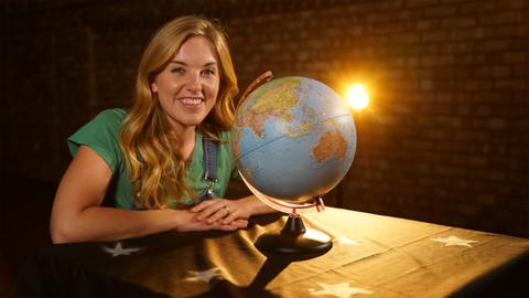 Maddie in front of a globe.